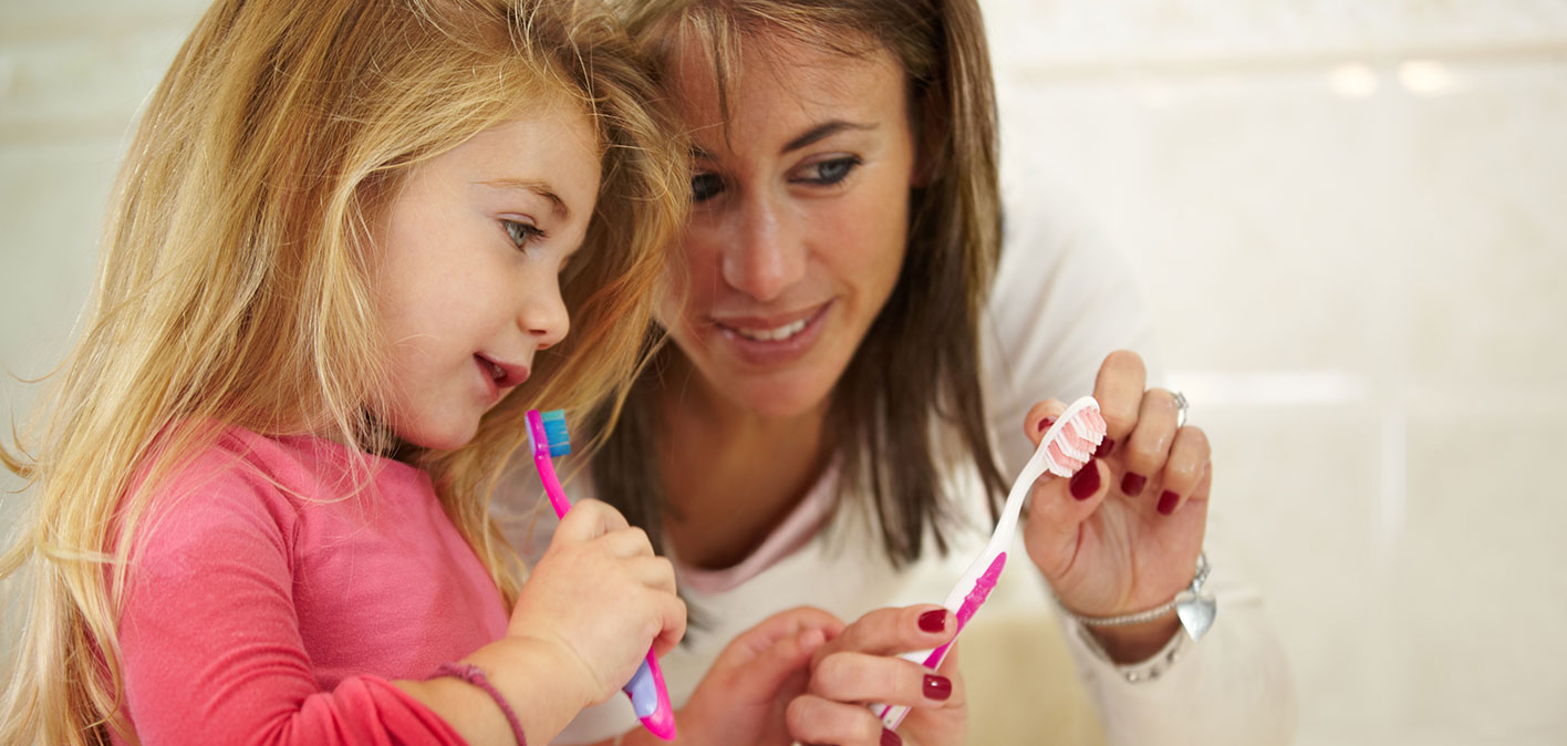 Mother and daughter brushing teeth